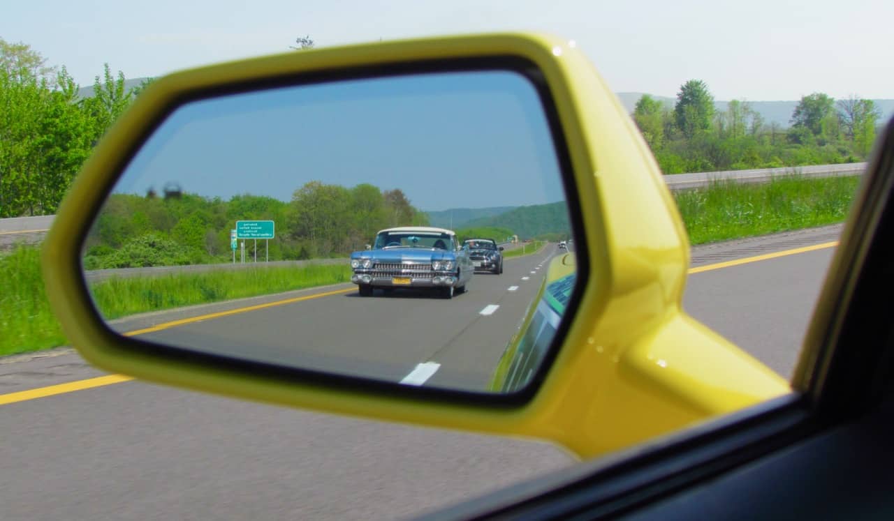 Reflexion des verkehrsflusses auf asphaltstraße im seitenspiegel des blauen  suv. auto-außenspiegel mit konvexem spiegel für sicheres fahren.