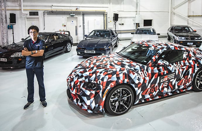 Tetsuya Tada, the chief engineer of the new A90 Toyota Supra, poses with his creation and examples from the past four Supra generations. | Toyota GB photo